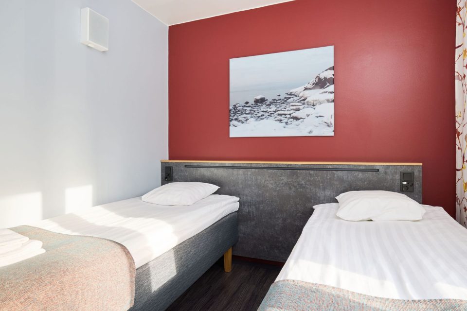 Hotel room for two beds Two single beds in a hotel room. Painting on the wall.