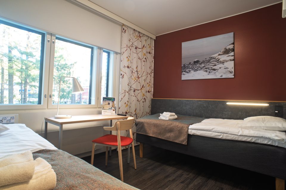 Linnasmäki hotel twin Linnasmäki's twin room with two separate beds and a desk by the window